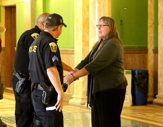 Linda Kenoyer being arrested during the third day of sit-ins at the Montana Capitol. (Coal Export Action / Rae Breaux)