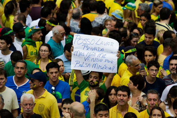 At a pro-impeachment march in São Paulo on March 15 a man holds a sign that says: “I’d rather clean toilets than sell myself for the misery allowance,” referring to Bolsa Família, the government’s basic income program. (Flickr/Alice Vergueiro)