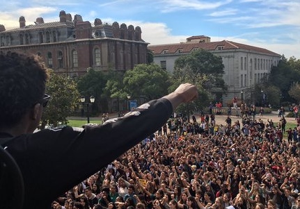 A student makes a fist to the crowd below. (Twitter)