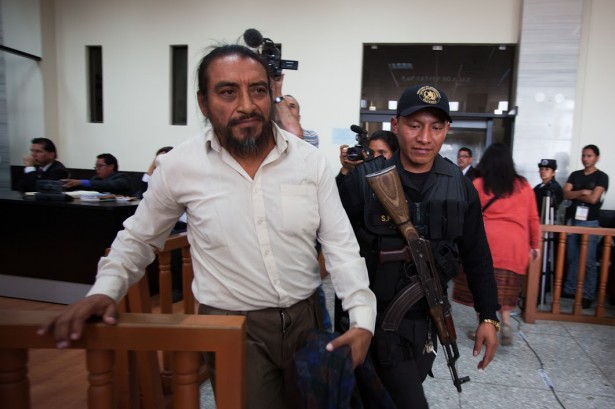 Rigoberto Juarez is escorted back to the holding cell within the court room in Guatemala City by an armed guard. (WNV/Jeff Abbott)