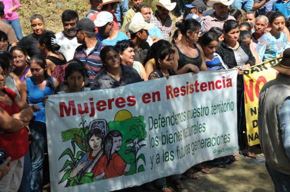 The Communities in Resistance hold a banner that reads "Women in Resistance" during a confrontation with mining company agitators. (GHRC)
