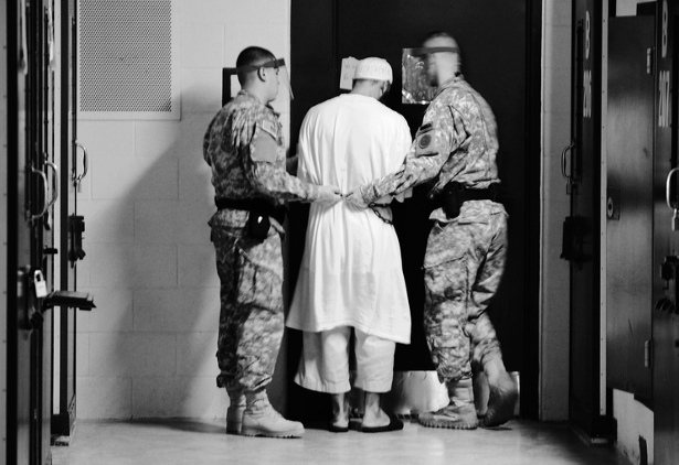 Guards from Camp 5 at Joint Task Force Guantanamo escort a detainee from his cell to a recreational facility within the camp. (Flickr/Kilho Park)