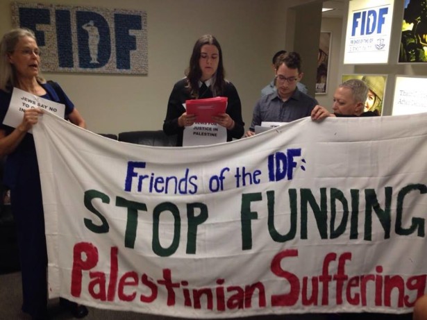 Jewish Voice for Peace members unfurl a banner at the Friends of IDF office in New York City. (Facebook)