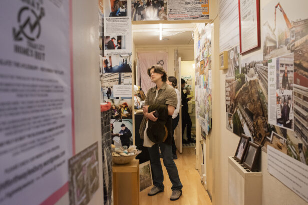 A visit looks at a wall covered in pamphlets in Aysen's hallway