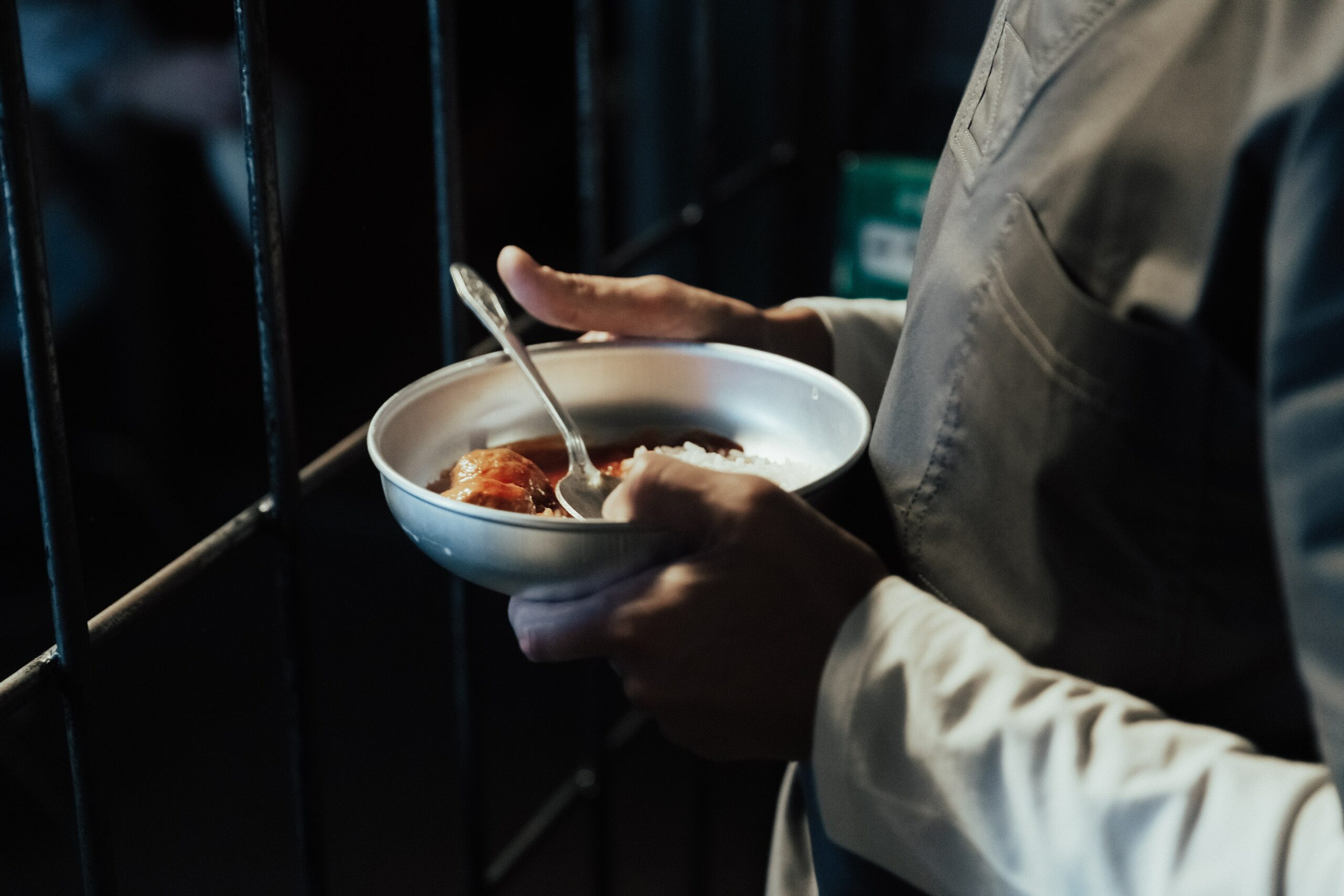A prisoner holds a bowl of food