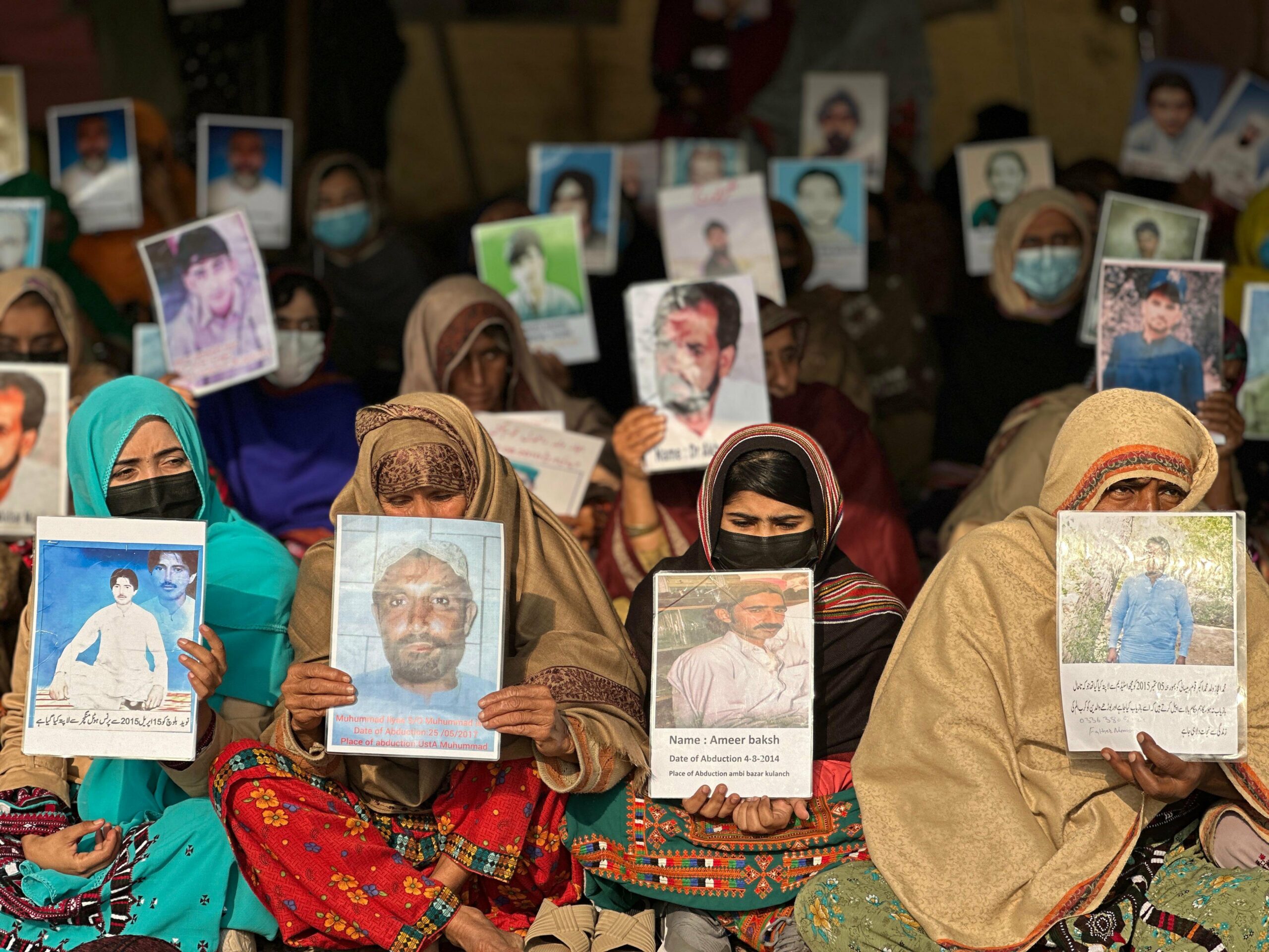 Women hold signs at Balochistan missing people protest