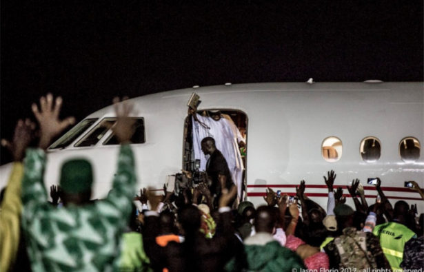 Deposed President Jammeh waves goodbye to followers as he gets on an airplane