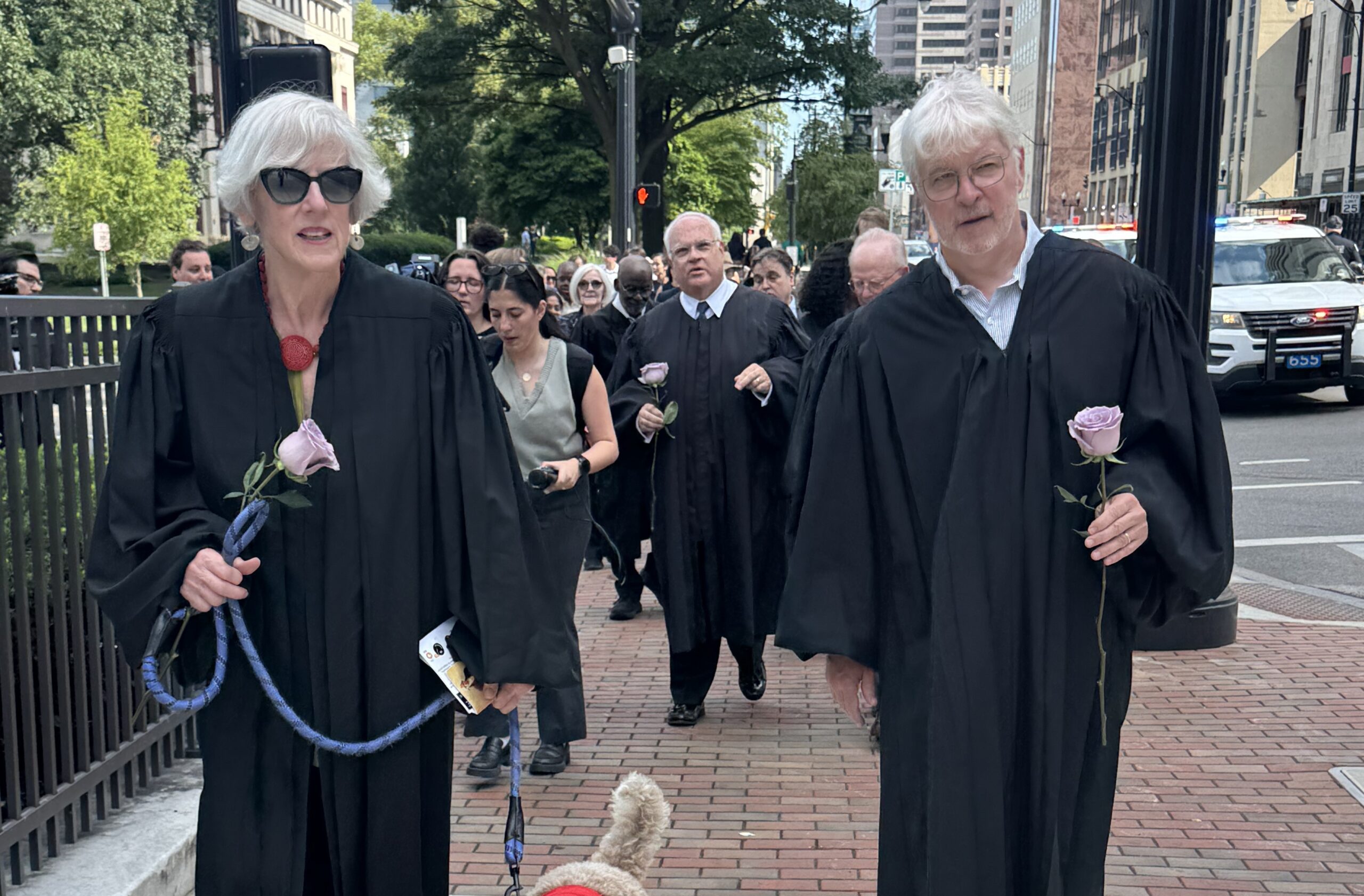 Ohio Chief Justice Maureen O&rsquo;Connor (ret.) and Ohio Justice Mike Donnelly (ret.) marching with lavendar roses in Columbus, Ohio on July 8.