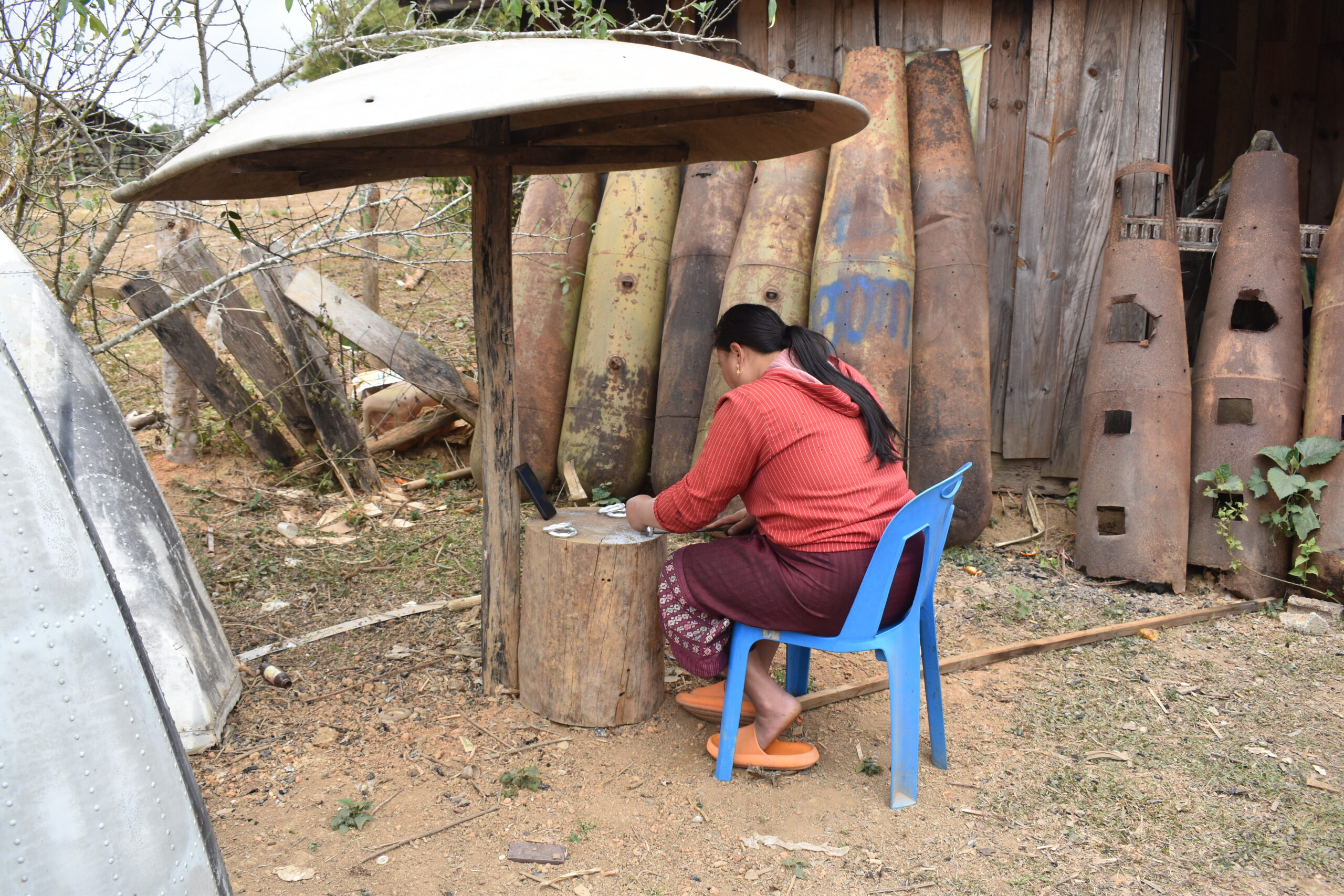 A worker in the village of Ban Napia, Xieng Khouang province files down bracelets made from the melted down aluminum from bombs dropped by the U.S. during the war.