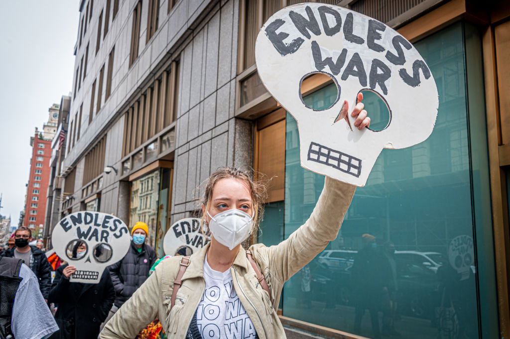 Participants holding signs against endless war during a march in front of the IRS offices in New York City