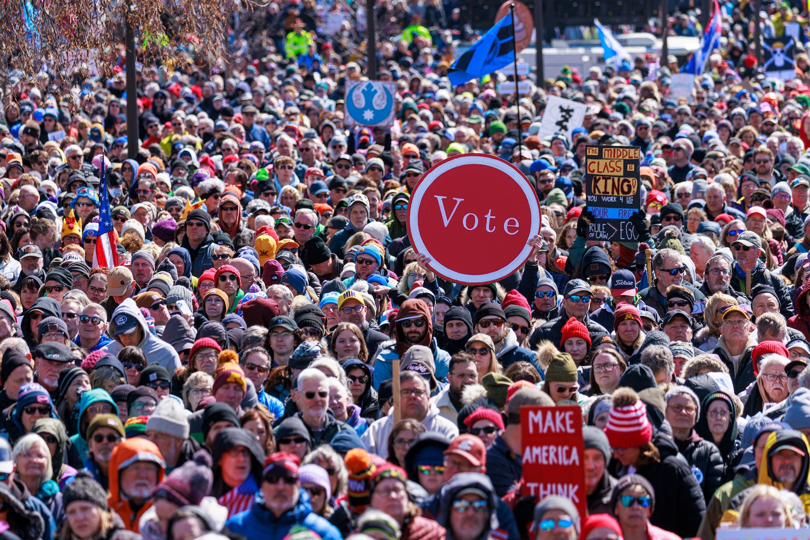 A person holds up a sign reading 